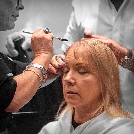 Placing the bondable topper onto a womans head