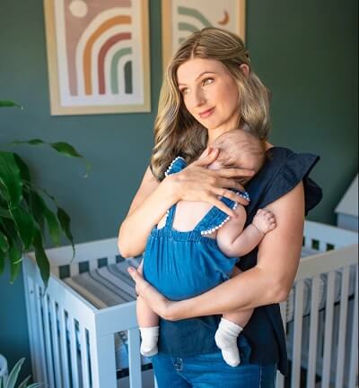 Woman wearing a smartlace wig whole holding her baby