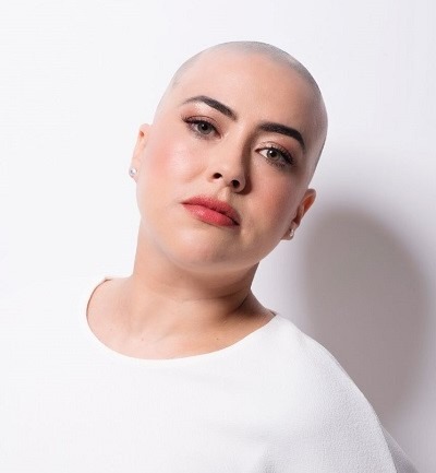 Lady wearing a white t-shirt who is completely bald