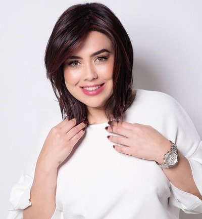 Smiling lady wearing a brown wig to cover her hair loss